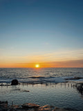 Sunset over the ocean with a wooden platform in the foreground